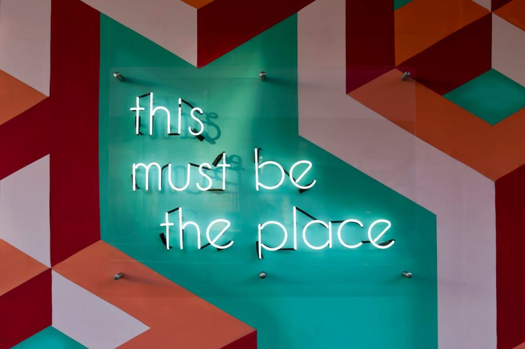 photo-of-led-signage-on-the-wall-942317 Colorful geometric wall featuring a glowing neon sign with an inspirational quote.
